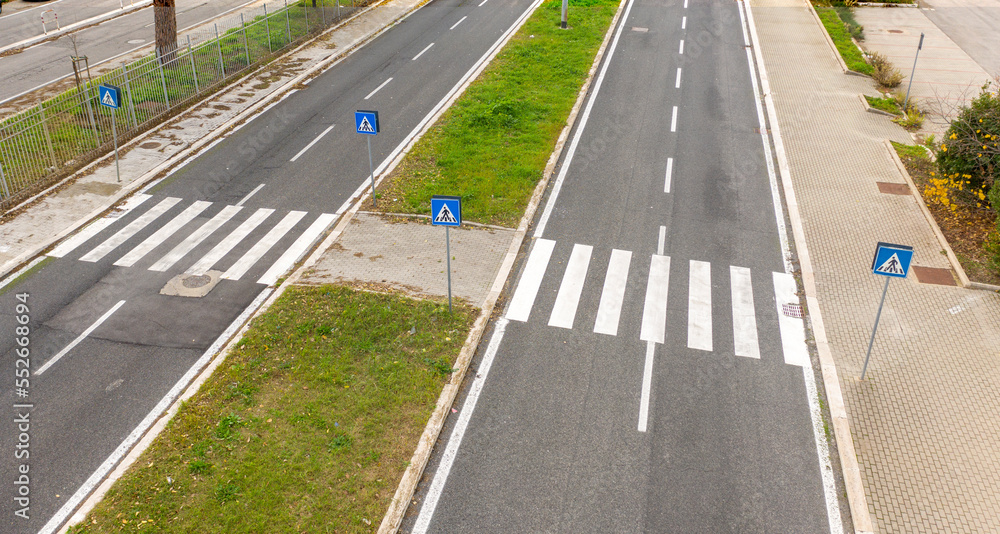Aerial view two parallel roads with pedestrian crossings. The streets are empty. Between the streets there are grass flowerbeds. Aerial view two parallel roads with pedestrian crossings. The streets are empty. Between the streets there are grass flowerbeds.