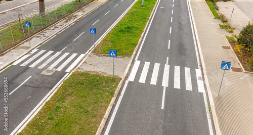 Aerial view two parallel roads with pedestrian crossings. The streets are empty. Between the streets there are grass flowerbeds.