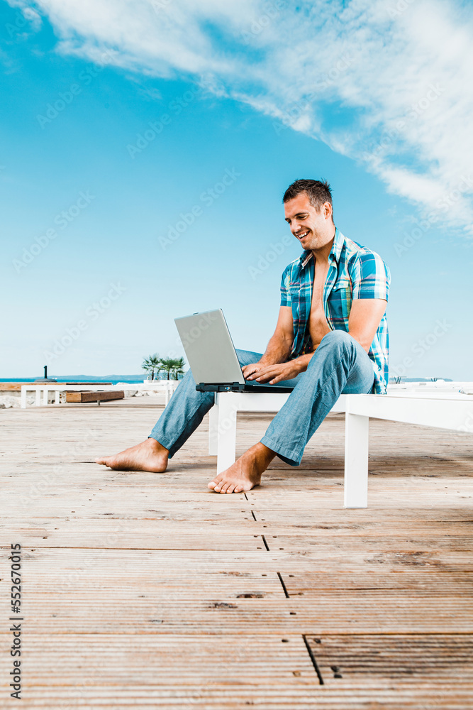 Businessman working on laptop on the beach
