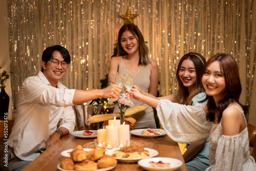 Young people clinking with glass of champagne to celebrate and toasting with happiness while dinner