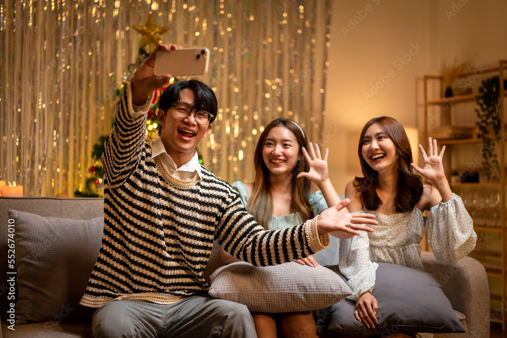 Young people sitting on the couch to smiling with enjoying and using smartphone to selfie together