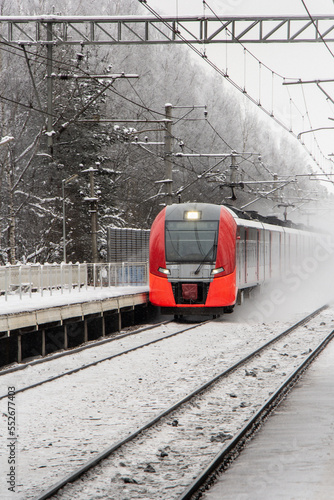 Red train rushing in the snow