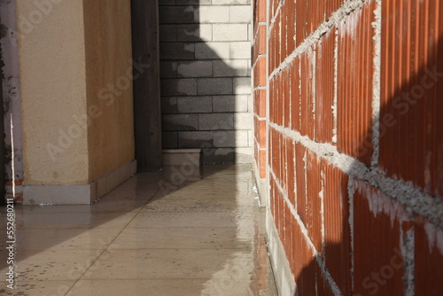 Building, new house construction, brick walls, rainy weather construction, wet floor. Flooded floor and construction site concept, perspective view