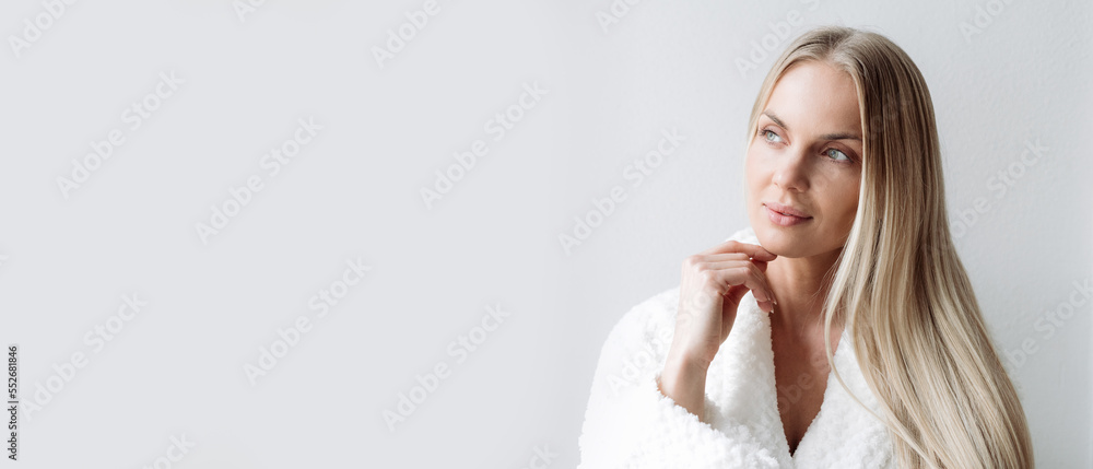 Thoughtful woman in bathrobe choosing beauty procedure Thoughtful woman in bathrobe choosing beauty procedure
