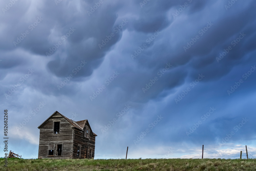 Old farmstead on the prairies under a stormy sky; Saskatchewan, Canada Old farmstead on the prairies under a stormy sky; Saskatchewan, Canada