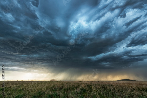 Rainfall in the distance on the prairies under ominous storm clouds; Saskatchewan, Canada photo