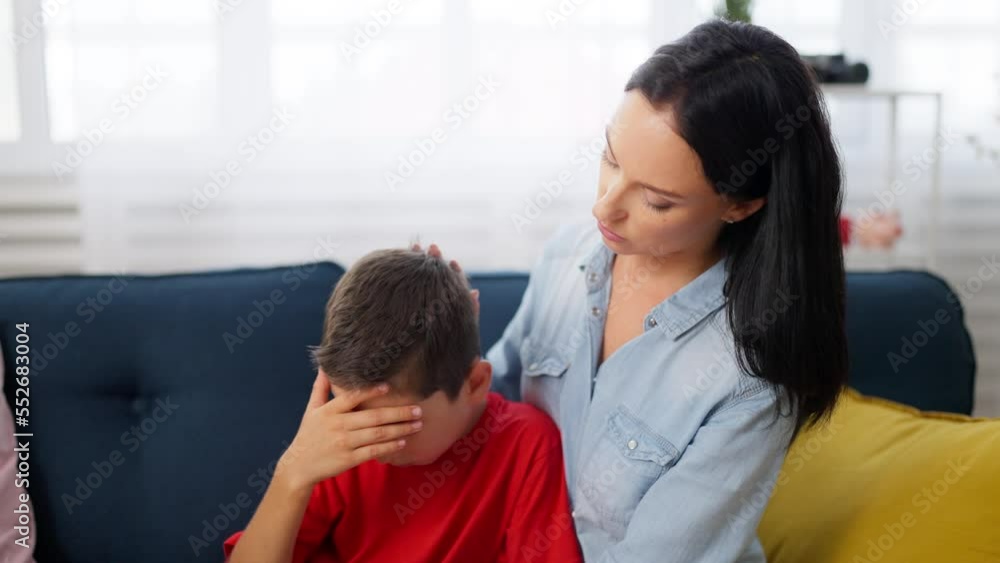 Schoolboy crying because of problems in school, mom hugging and comforting him Schoolboy crying because of problems in school, mom hugging and comforting him