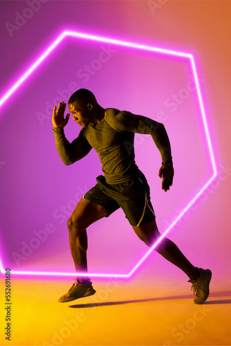 Illuminated hexagon and african american male athlete running over against gradient background © vectorfusionart