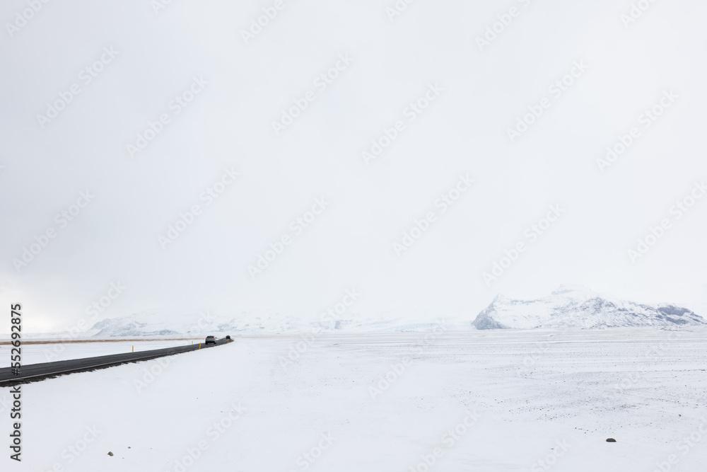 Obraz premium Road Leading Through the Frozen Snowy Landscape of Southern Iceland in Winter