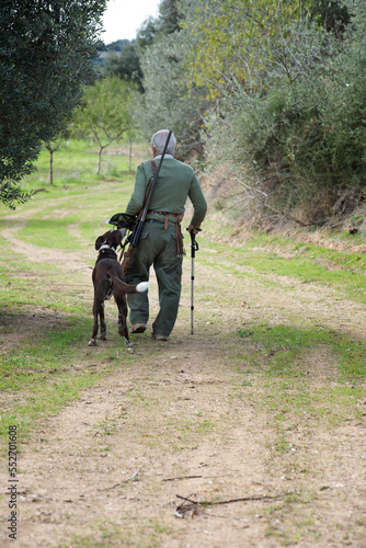 elderly hunter with dog walking in the bush