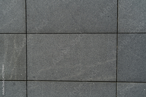 gray tile wall front view tiles in the shape of large rectangles texture and background of granite street tiles