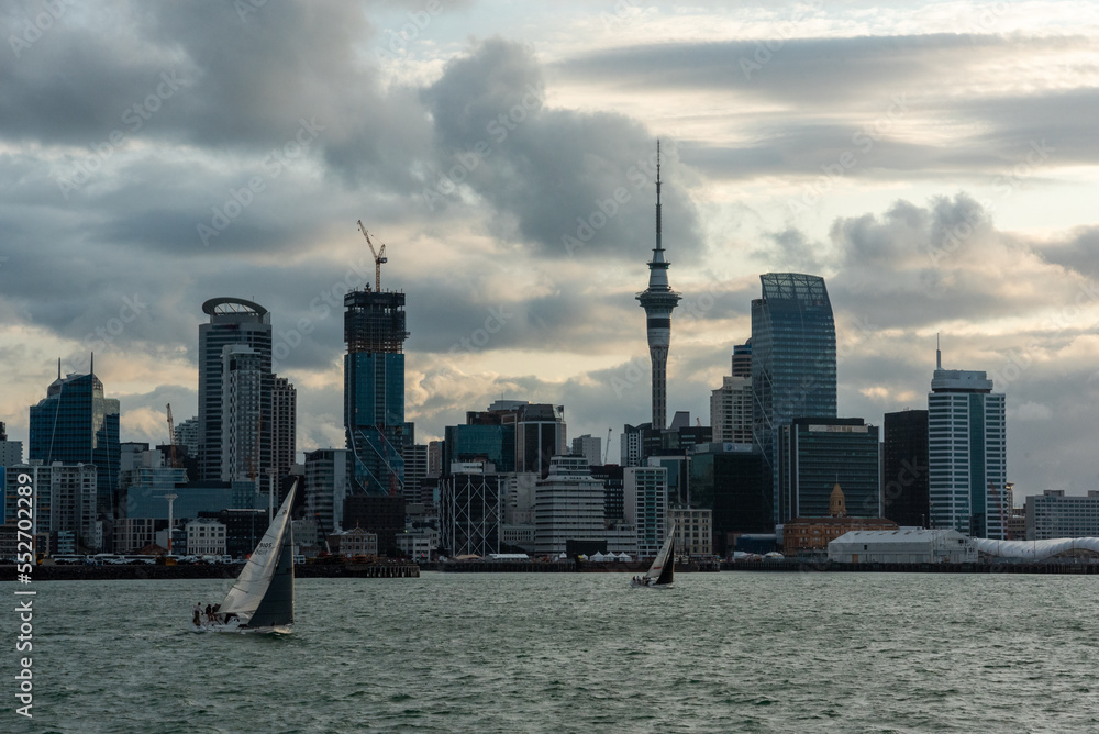 Obraz premium 2020, JANUARY 04 - AUCKLAND, NEW ZEALAND - Famous skyline of Auckland Central Business District during sunset, people anjoying the warm summer evening on their sailboats