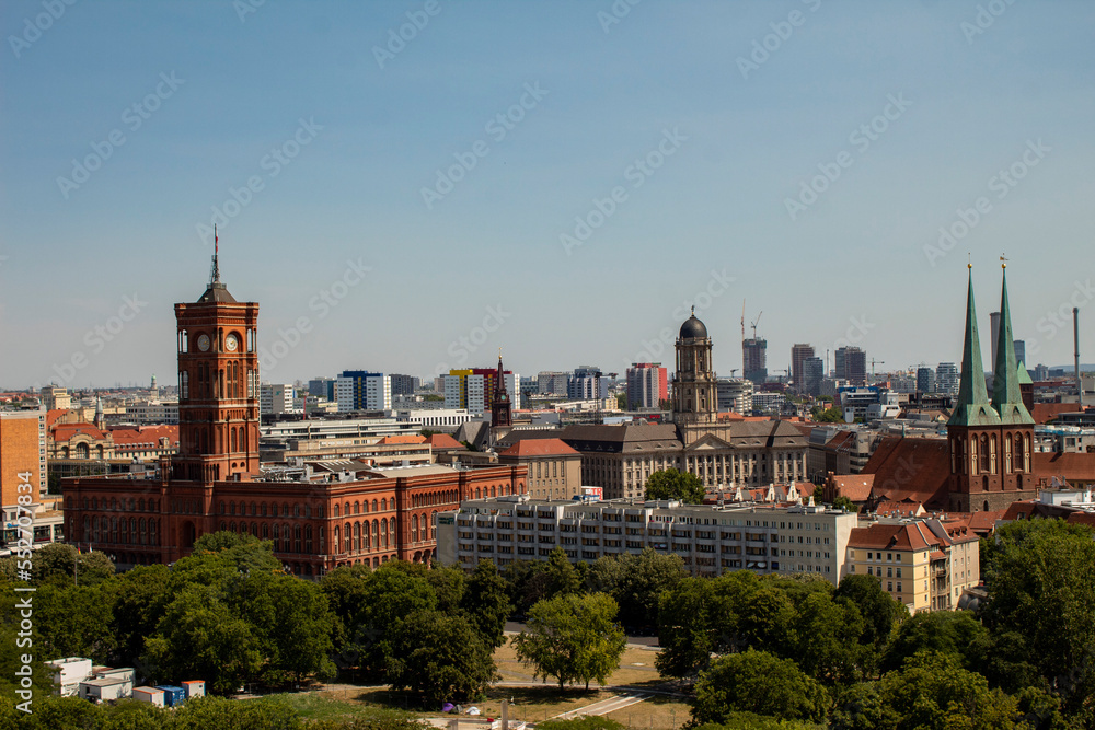 A little top view of the red town hall in berlin, also known as the rotes rathaus, other important buildings, city view with sky and trees.