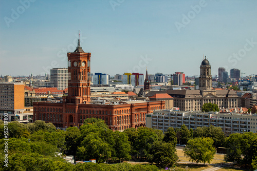 A little top view of the red town hall in berlin, also known as the rotes rathaus, other important buildings, city view with sky and trees.