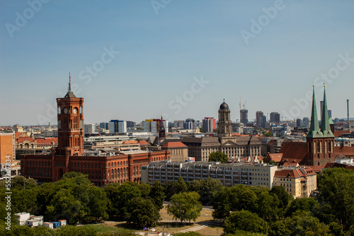 A little top view of the red town hall in berlin, also known as the rotes rathaus, other important buildings, city view with sky and trees.