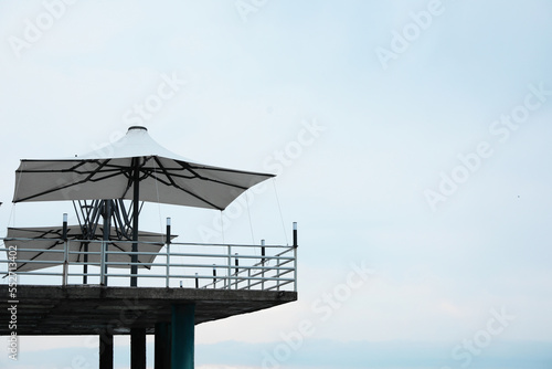 Beautiful view of pier with beach umbrellas near sea. Space for text