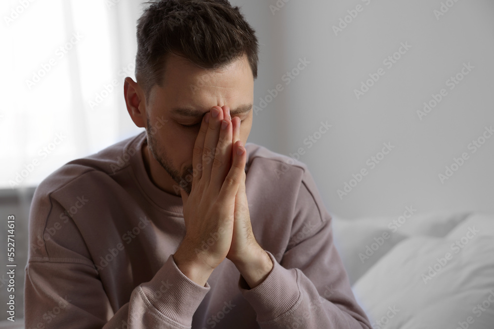 Upset man sulking at home, space for text. Loneliness concept Upset man sulking at home, space for text. Loneliness concept