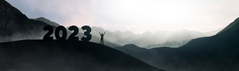 silhouette forming the new year 2023 on the top of the mountain
