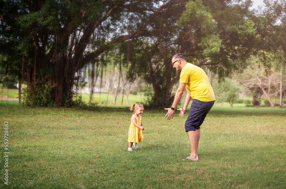 Daughter runs to dad in the park outdoors