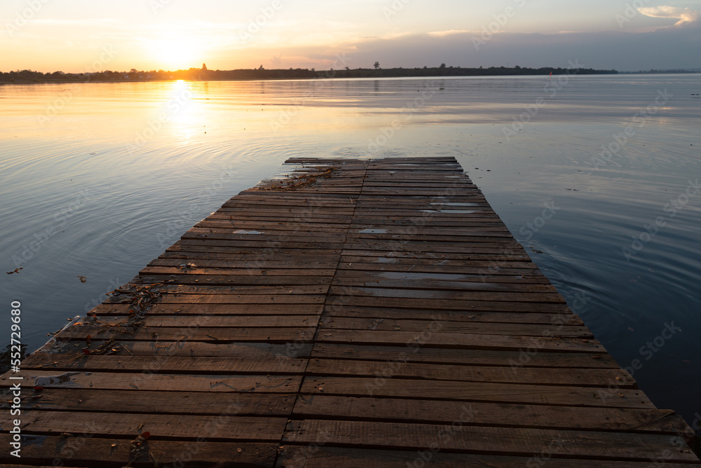 Wooden pier at sunset on a lake in Bueng Kan, Thailand 2022 