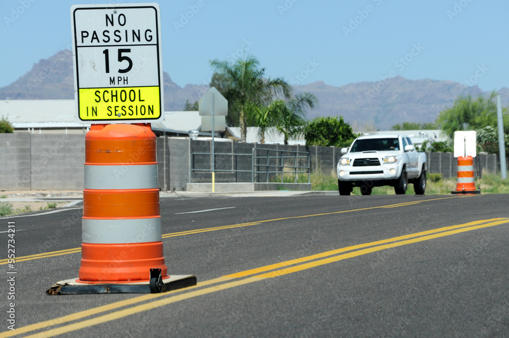 School zone no passing, 15 milesperhour safety sign in the middle of a twoway road Stock