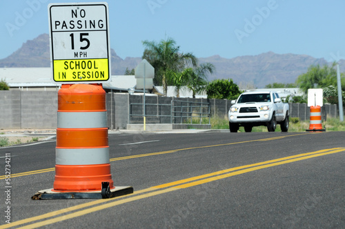 Tablou pe pânză Portable school zone sign with 15 MPH speed limit and no passing warning placed