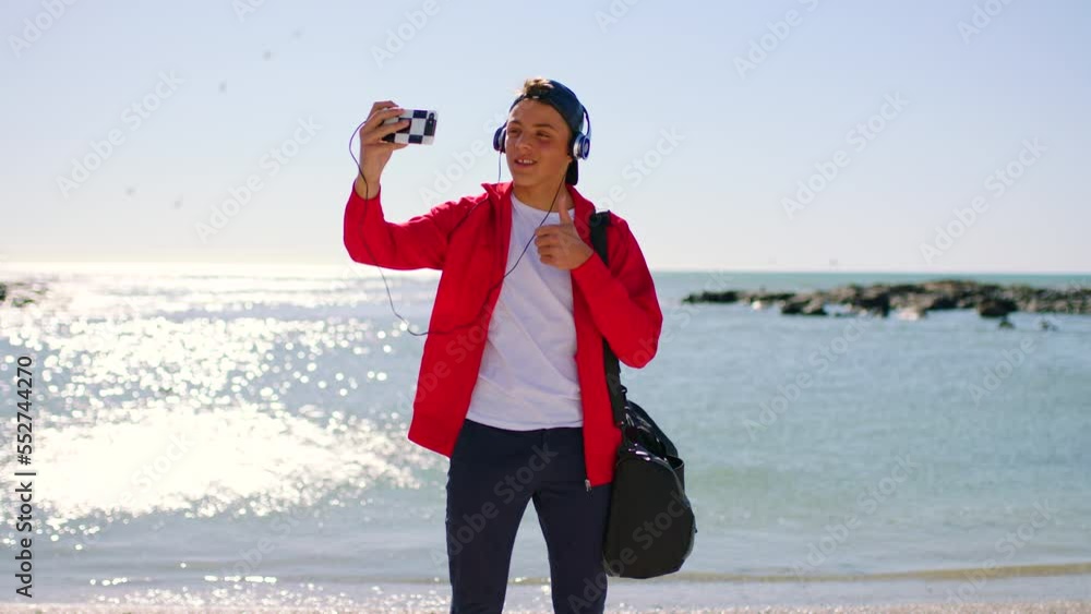 Beach, smartphone and man with headphones in selfie for social media post, profile picture and travel blog of ocean. Youth, gen z and teenager fashion with audio and cellphone photography at a sea Beach, smartphone and man with headphones in selfie for social media post, profile picture and travel blog of ocean. Youth, gen z and teenager fashion with audio and cellphone photography at a sea