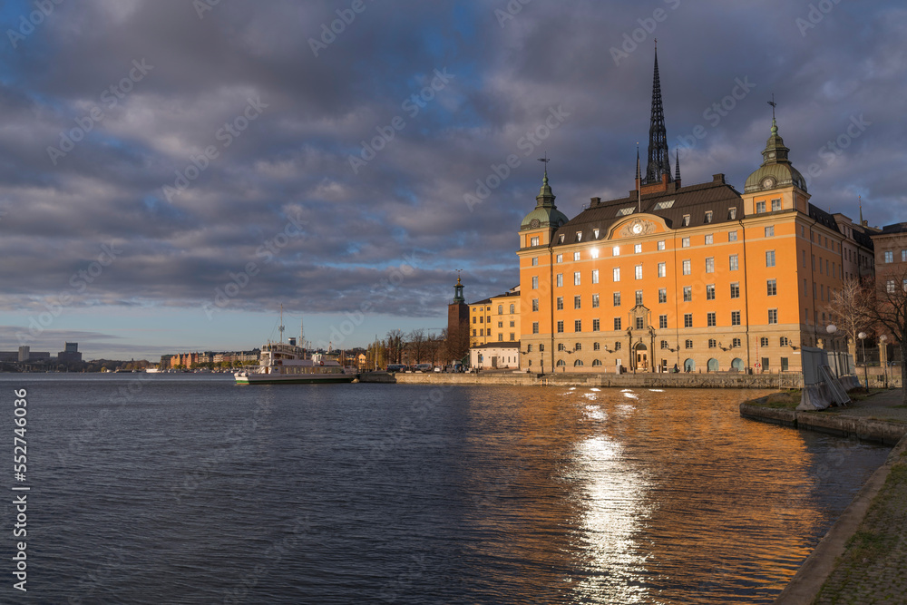 Old court house and water front at the bay Riddarfjärden a winter day with dark clouds and low sun in Stockholm