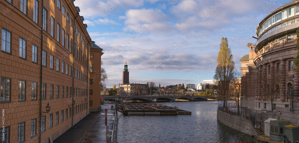 The canal Stallkanalen at the Swedish Parliament house and skyline with the Town City Hall a winter day with dark clouds and low sun in Stockholm