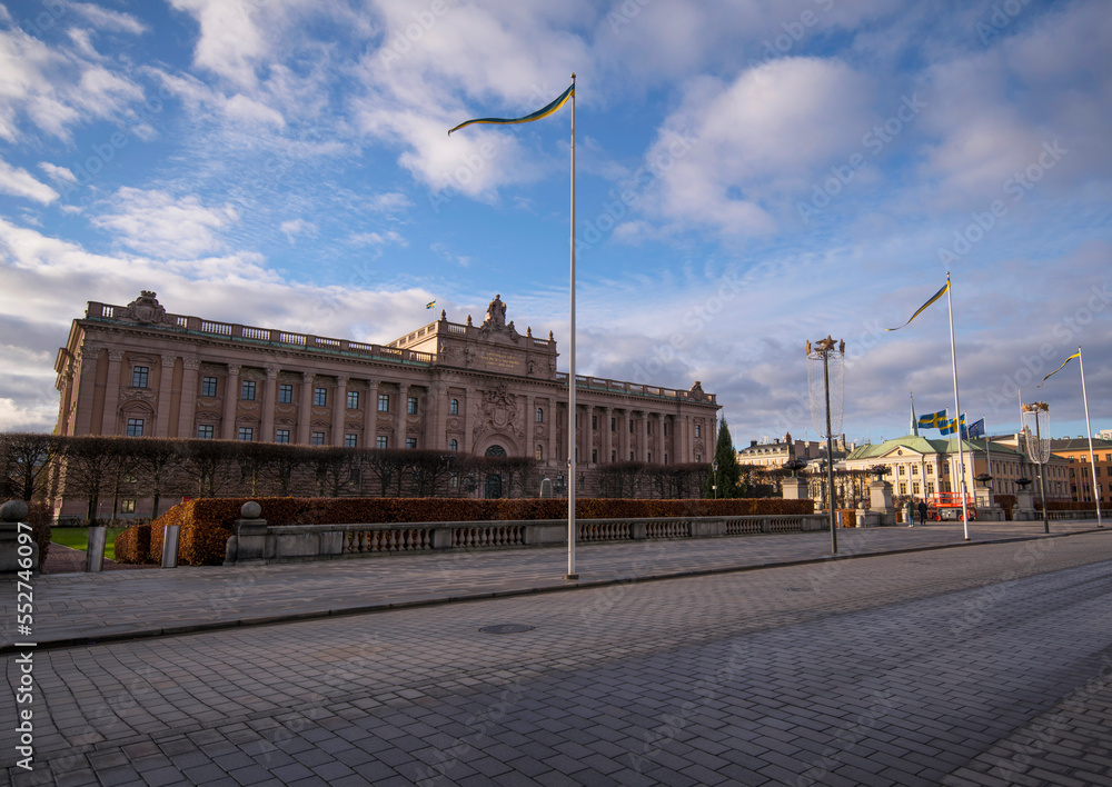 The Swedish Parliament house and skyline with the Town City Hall a winter day with dark clouds and low sun in Stockholm