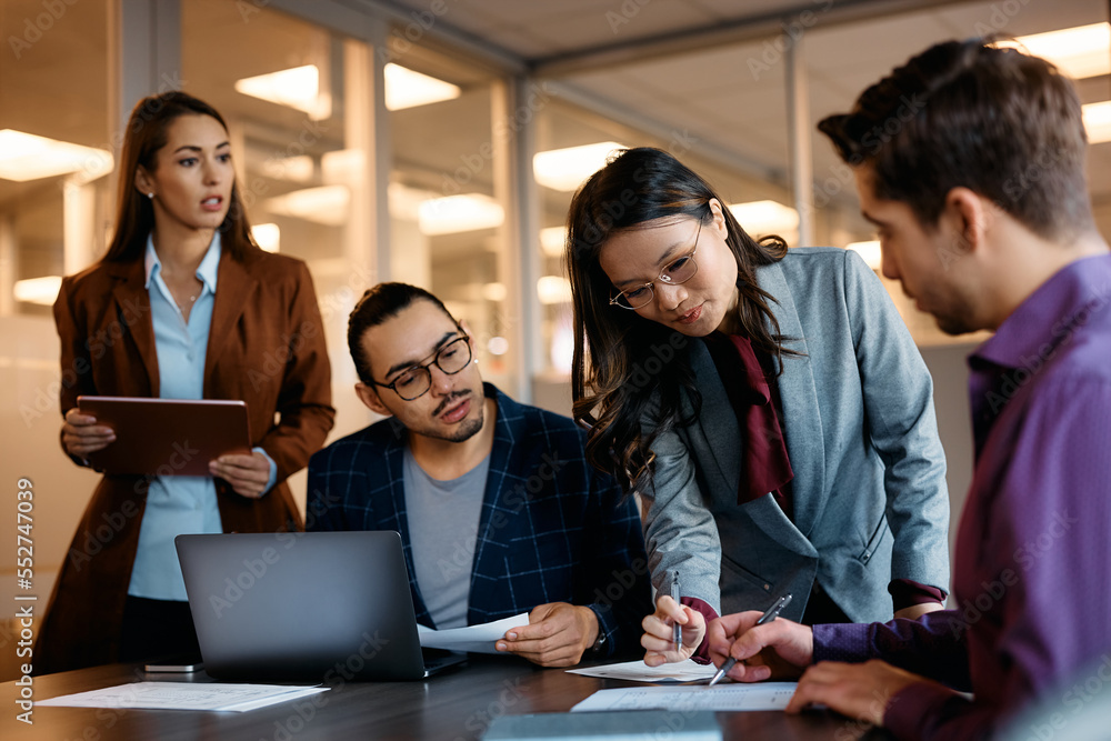 Happy Asian female CEO having business meeting with her coworkers in office. Happy Asian female CEO having business meeting with her coworkers in office.