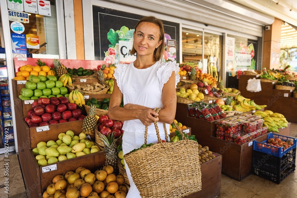 Obraz premium a young woman buys fruits and vegetables at a market. fresh and healthy food. High quality photo