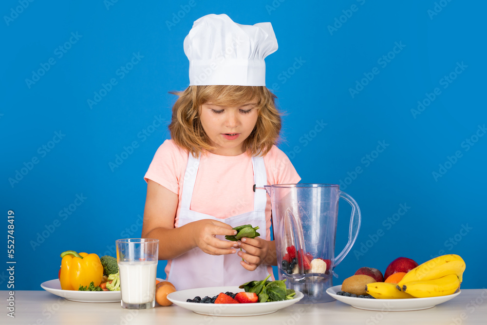 Portrait of chef child in cook hat. Cooking at home, kid boy preparing food from vegetable and fruits. Healthy eating. Portrait of chef child in cook hat. Cooking at home, kid boy preparing food from vegetable and fruits. Healthy eating.