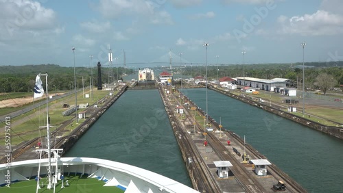 The ship passes the lock of the Panama Canal.Panama Canal cargo bulk ship passing through locks. Locks system lifts a ship 85 feet between the Atlantic and Pacific Ocean. Tug boats electric trains. photo