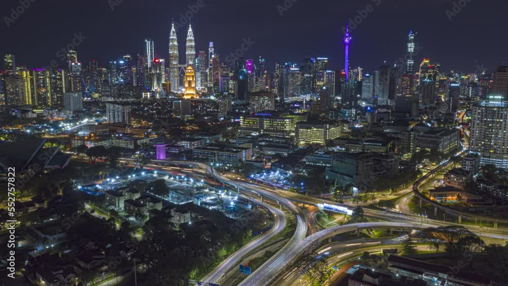 Aerial time lapse overlooking a busy roundabout and city streets against a city skyline in the background at night with city lights in Kuala Lumpur, Malaysia. Prores 4KUHD Aerial time lapse overlooking a busy roundabout and city streets against a city skyline in the background at night with city lights in Kuala Lumpur, Malaysia. Prores 4KUHD