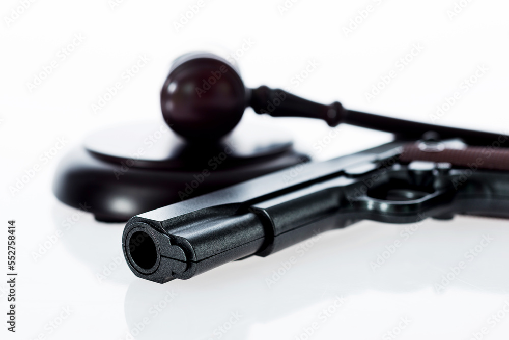 A gavel and gun isolated on white background A gavel and gun isolated on white background