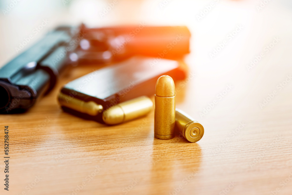 Gun with ammunition on wooden table Gun with ammunition on wooden table