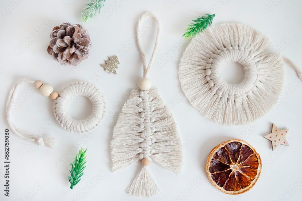 Obraz premium Christmas tree toys made of natural materials, cotton thread. Top view. New Year's layout of macrame products for Christmas, pendants on a white background. Eco decorations, ornaments, hand made