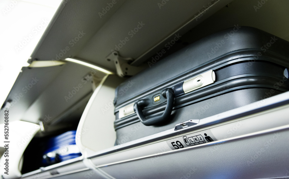 Suitcase on the top shelf of airplane Suitcase on the top shelf of airplane