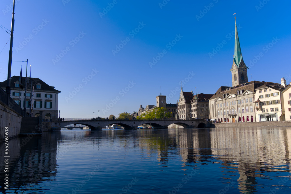 Beautiful cityscape of the old town of Zürich with Limmat River in the foreground with church Women's Minster on a sunny late summer morning. Photo taken September 22nd, 2022, Zurich, Switzerland.