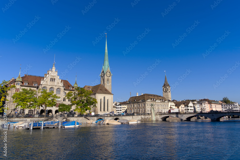 Beautiful cityscape of the old town of Zürich with church towers and Limmat River in the foreground on a sunny late summer morning. Photo taken September 22nd, 2022, Zurich, Switzerland.