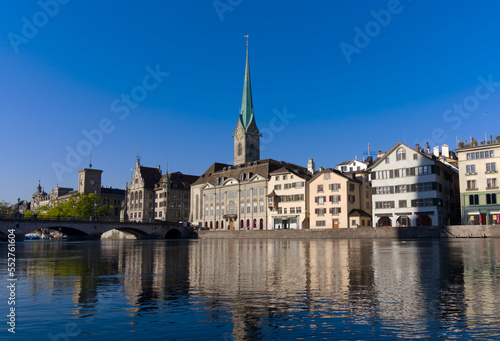 Beautiful cityscape of the old town of Zürich with Limmat River in the foreground with church Women's Minster on a sunny late summer morning. Photo taken September 22nd, 2022, Zurich, Switzerland.