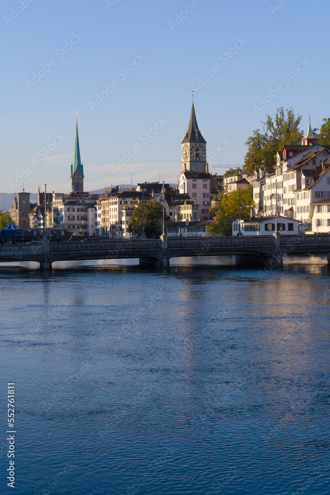Beautiful cityscape of the old town of Zürich with church towers and Limmat River in the foreground on a sunny late summer morning. Photo taken September 22nd, 2022, Zurich, Switzerland.