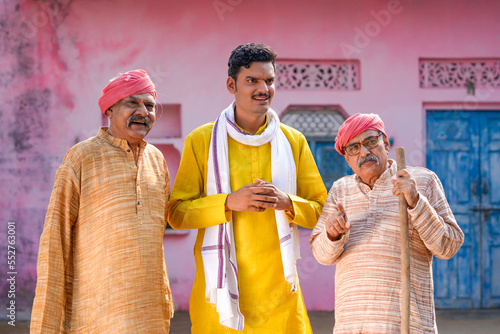 Canvastavla Three indian villagers standing discussing at out of home.