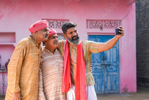 Indian villagers group taking selfie in smartphone