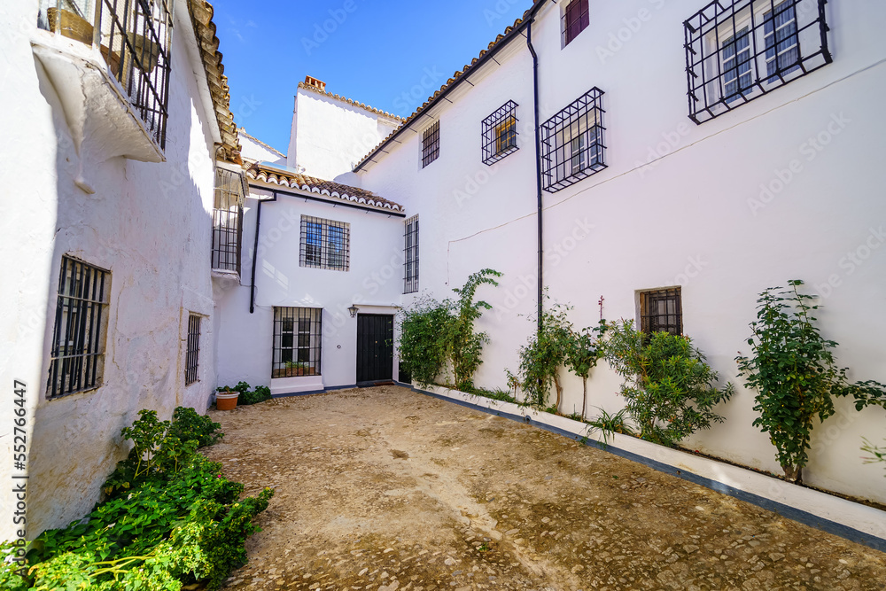 Houses with white facades and metal grilled windows in the picturesque Andalusian village of Ronda, Malaga.