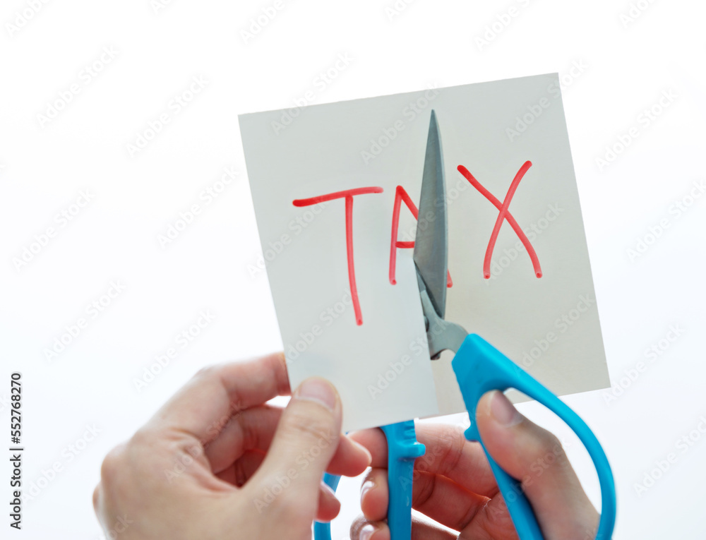Hand holding scissors cut tax Hand holding scissors cut tax
