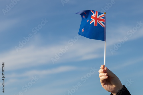 New Zealand flag in hand flutters in the wind against the sky  independence national day of New Zealand  country freedom  patriotism  Public Holiday  patriotic festival
