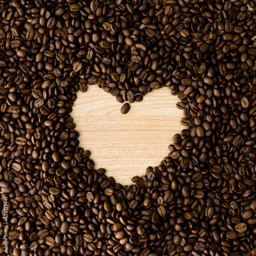 Heart shape frame from coffee beans on wooden table Heart shape frame from coffee beans on wooden table