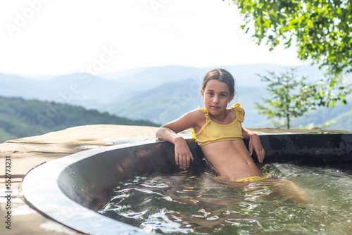 little girl in a hot tub in the mountains, summer